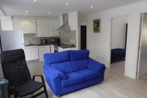 バレンシアにあるMalvarossa apartment near beachのリビングルーム(青いソファ付)、キッチン