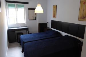 バレンシアにあるMalvarossa apartment near beachのベッドルーム1室(ベッド2台、窓、デスク付)