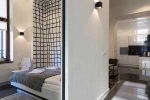 a bedroom with a bed and a kitchen at Art Room Boutique Apartment in Krakow