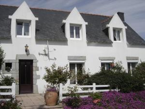 ein weißes Haus mit einem weißen Zaun und lila Blumen in der Unterkunft Chambres d'Hôtes Ty Mezad in Séné