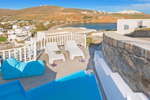 a balcony with chairs and a view of the ocean at Aegean Sea Villas in Livadi Astypalaias