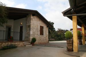 una casa con un edificio de piedra con porche en Agriturismo Amicizia, en Cassano delle Murge