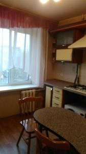 cocina con mesa, sillas y ventana en Apartment - Panasa Myrnoho 20, en Mýrhorod