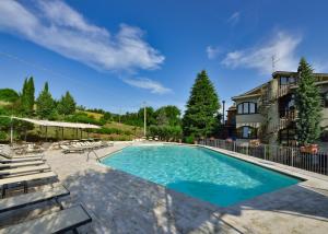 a swimming pool with chairs and a building at Villa Ambra in Sant'Albino