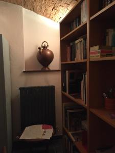 a room with a book shelf with a vase on it at All' Ombra del Portico in Bologna