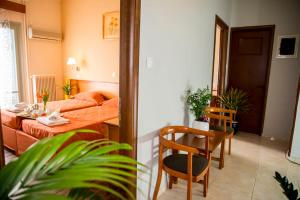 a living room with a bed and a table and chairs at Togias Hotel in Egina