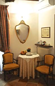 a room with a table and two chairs and a mirror at Il Giardino Incantato in Monterosso al Mare