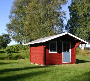 uma pequena casa vermelha num campo de relva em Ferienhaus Vitsand em Torsby