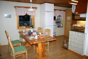 uma cozinha com uma mesa de madeira e cadeiras num quarto em Ferienhaus Vitsand em Torsby
