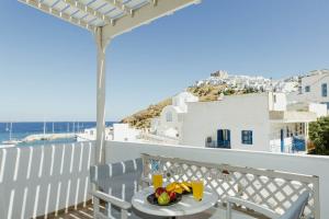 a table on a balcony with a view of the ocean at Viva Mare Studios in Astypalaia