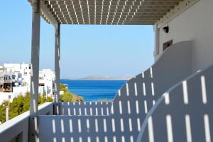 a white fence with a view of the ocean at Viva Mare Studios in Astypalaia Town