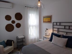 コルドバにあるApartamento VIANA HOMEのベッドルーム1室(ベッド1台、椅子、窓付)