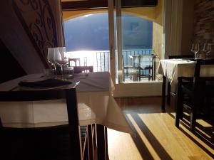 a dining room with a table and a view of the ocean at Foresteria Lombarda La Spiaggia in Lierna