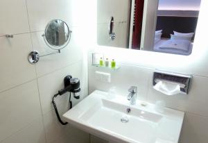 a bathroom with a sink and a mirror at Hotel-Restaurant Goldenstedt in Delmenhorst