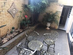 a patio with chairs and tables and a building at Pousada Hostel Universitário in Londrina