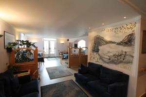a living room with a couch and a painting on the wall at Hotel Florida in Molveno