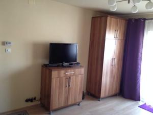a living room with a flat screen tv and wooden cabinets at Sunshine View in Cluj-Napoca