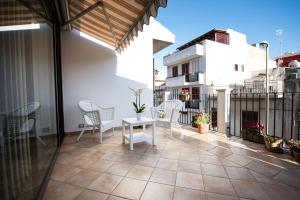 un patio con sedie e un tavolo sul balcone. di Cabrera House a Pozzallo