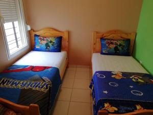 two beds in a small room with at Cozy Appartement in Douar Ben Chellal