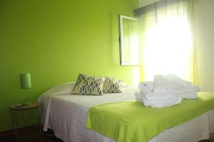 zielony pokój z łóżkiem z ręcznikami w obiekcie ApartAnita w mieście Ponta Delgada