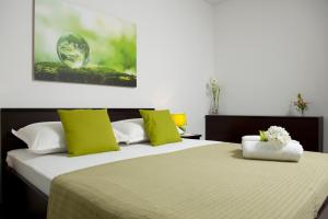 1 Schlafzimmer mit 2 Betten und grünen und weißen Kissen in der Unterkunft Apartman u srcu grada - Ilićev prolaz in Split