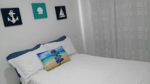 Una cama blanca con una almohada encima. en Apartamento de tres habitaciones en zona centro de San Andrés Islas - Edificio Comodoro 203, en San Andrés