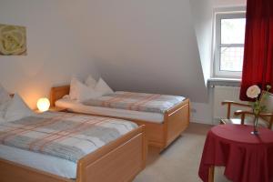 a bedroom with two beds and a table and a window at Ferienwohnung Zinne-Wigger in Steimbke