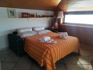 a bedroom with a bed with towels on it at Casa Diana in Giardini Naxos