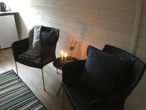 Dos sillas y una mesa con una vela. en Danhostel Rødding Centret en Rødding