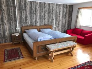 a bedroom with a bed and a red couch at Bergstätt Lodge in Immenstadt im Allgäu
