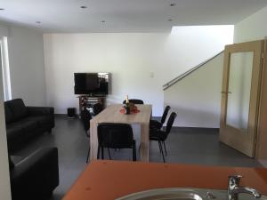 a living room with a table and chairs and a couch at Gîte Grewis in La Wantzenau +19 photos