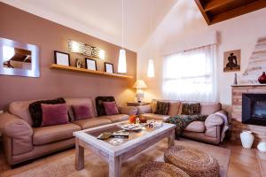 een woonkamer met een bank en een tafel bij Villa Hibiscus Centrum Corralejo Beach Private Pool Family in Corralejo