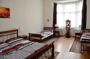 プラハにあるApartment in the heart of Pragueのベッド4台と窓が備わる客室です。