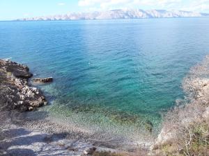 une grande étendue d'eau avec des montagnes en arrière-plan dans l'établissement Apartments Tomas, à Senj