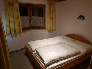 1 cama pequeña en un dormitorio con ventana en Haus Kathrin, en Kaprun