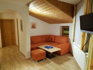 una sala de estar con un sofá y una mesa en Haus Kathrin, en Kaprun