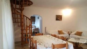 ein Wohnzimmer mit einem Tisch und einer Wendeltreppe in der Unterkunft Alexandros House in Vátos