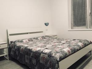 a bedroom with a bed with a floral comforter at Residenza Christian in Gravedona