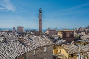 a view of a city with a clock tower at I Terzi Di Siena - Rooms Only in Siena
