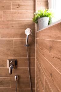 een douche in een badkamer met een plant aan de muur bij Croatica Suites Podsolarsko in Šibenik