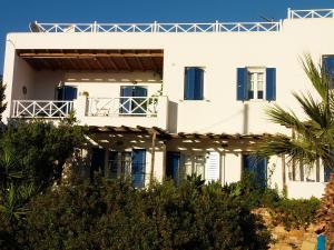 Casa blanca con persianas azules y árboles en Korali apartments, en Galissas