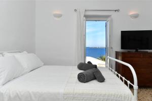 a bedroom with a bed with a television and the ocean at Kastro Traditional House in Parikia