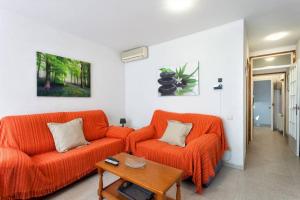 a living room with two orange couches and a table at Maison Lamic 2 in Lloret de Mar