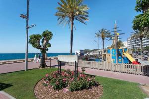 a park near the beach with a playground and palm trees at Maison Lamic 2 in Lloret de Mar