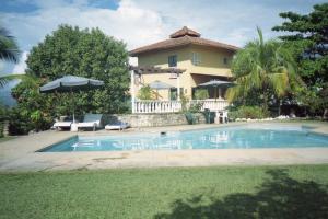 a villa with a swimming pool in front of a house at La Loma in Melgar