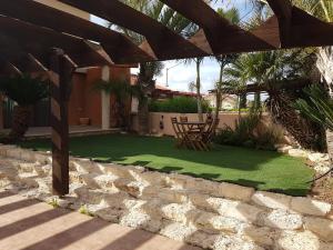 a patio with a lawn with a table and chairs at Desert Gat in Qiryat Gat