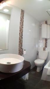 a white bathroom with a tub and a toilet at Posada Santa Juliana in Santillana del Mar