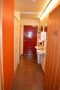 een badkamer met 2 wastafels en een rode deur bij Laugarfell Accommodation & Hot Springs in Laugarfell