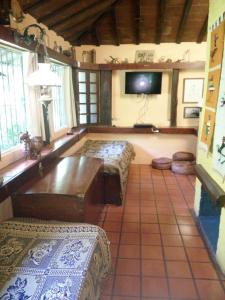 a room with two benches and a tv in a room at Casa de campo, surf, pesca y golf in Miramar