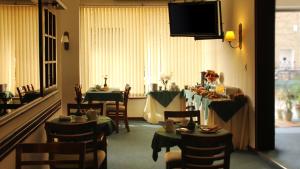 jadalnia z dwoma stołami i telewizorem w obiekcie Hotel Centro w mieście San José de Mayo